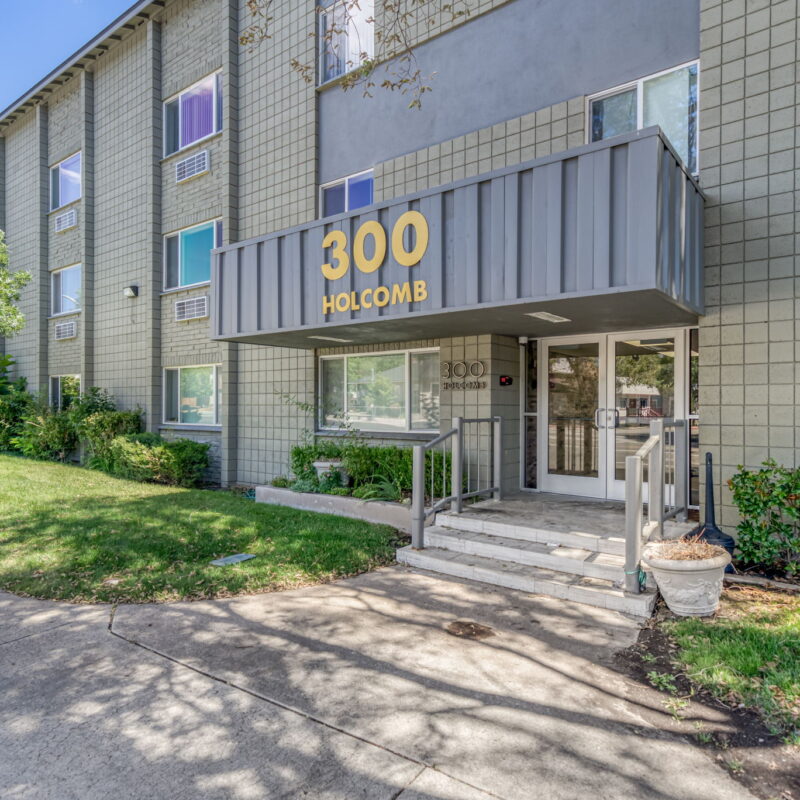 Entrance to 300 Holcomb building, grassy surroundings.