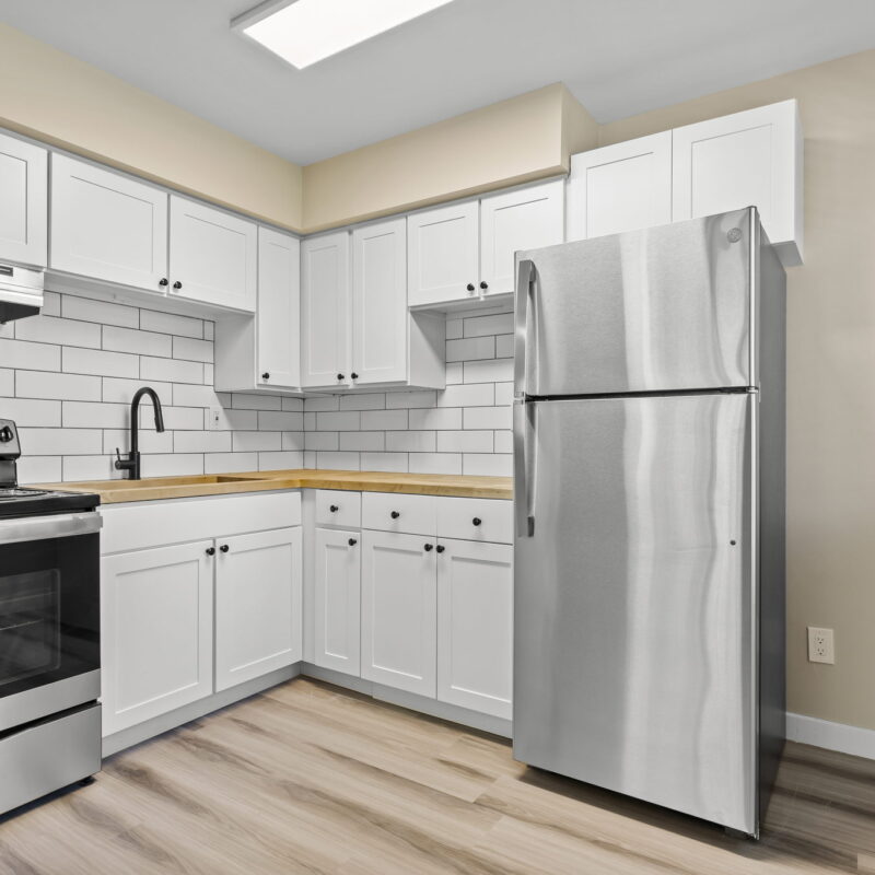 Modern kitchen with white cabinets and stainless steel appliances