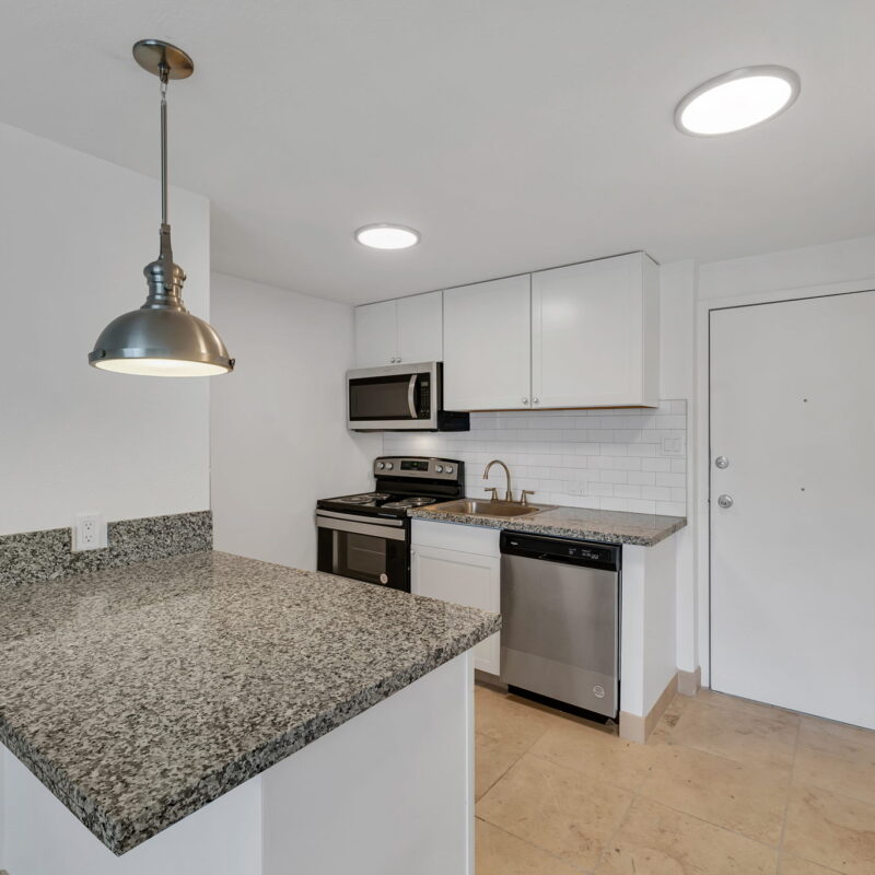 Modern kitchen with granite countertops and appliances.