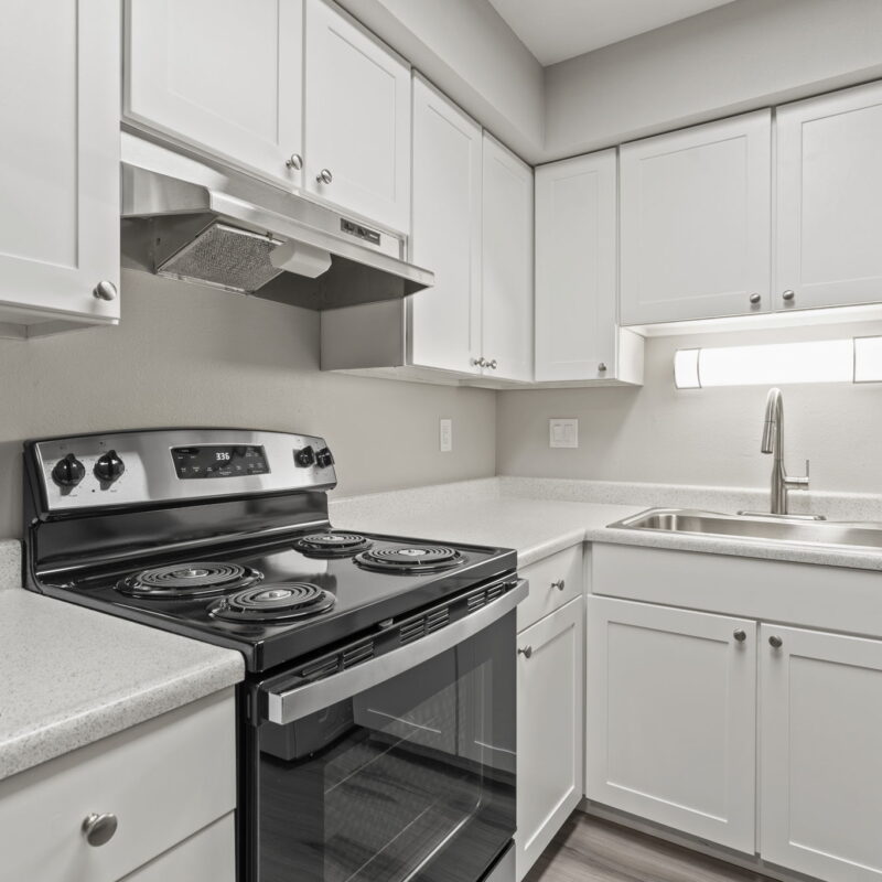 Modern kitchen with white cabinets and appliances.