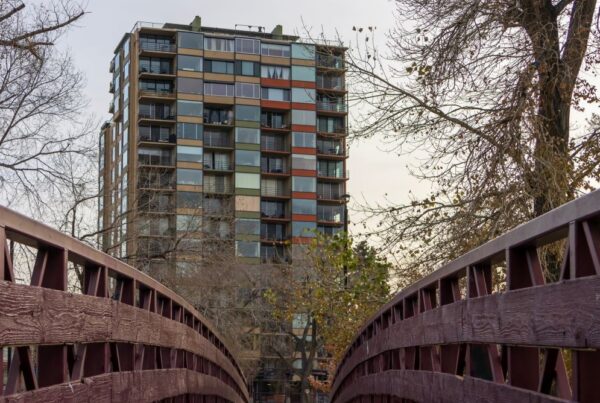 Colorful building behind a wooden bridge with trees