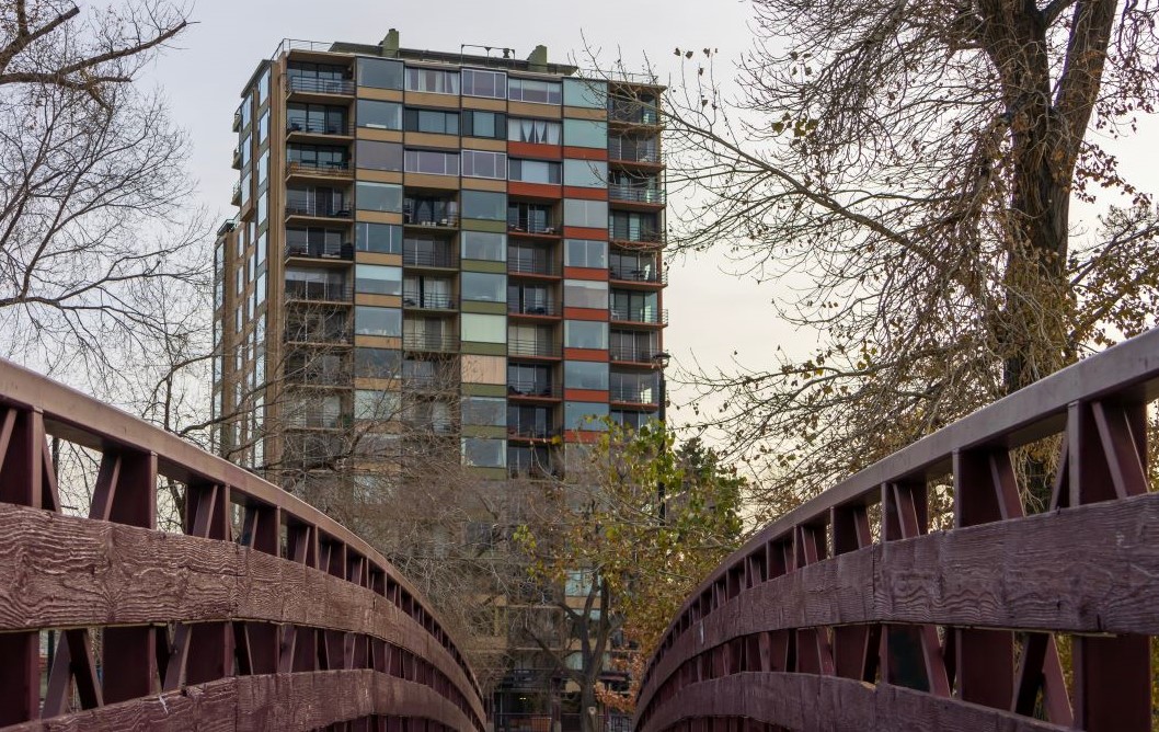 Colorful building behind a wooden bridge with trees